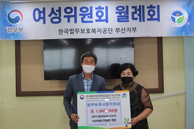 이정화 회장이 이흥수 지부장에게 법무보호사업지원금을 전달하고 기념촬영.(사진제공=한국법무보호복지공단부산지부)