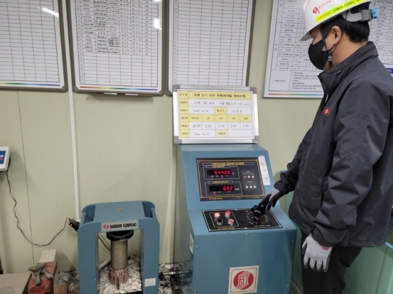 롯데건설이 롯데케미칼, 동남기업과 함께 개발한 화학 혼화제를 현장에 적용해 압축강도 테스트를 하는 모습.(사진=롯데건설)