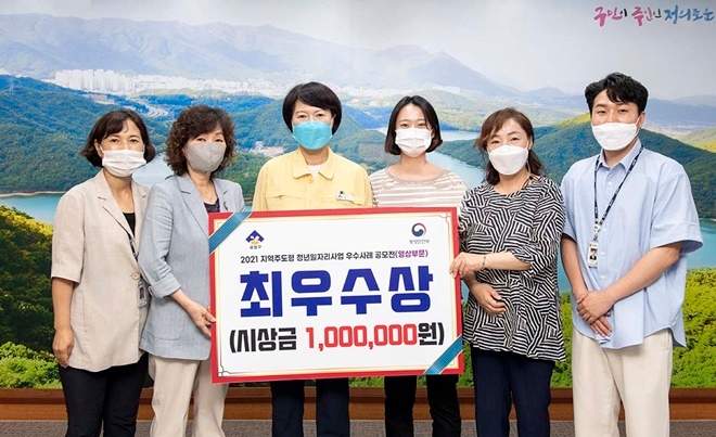 ‘2021년 지역주도형 청년일자리사업 우수사례 공모전’에서 영상 부문 최우수상을 수상한 김지예 씨(우측세번째)가 정미영 구청장(왼쪽 세번째) 등과 기념촬영.(사진제공=부산 금정구)