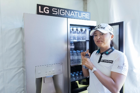 LG 시그니처 체험존에서 고진영 선수가 냉장고 안의 에비앙 생수를 꺼내 마시며 직접 제품을 체험해보고 있다. 사진=LG전자