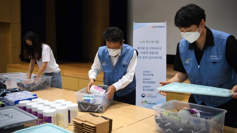 포스코건설 한성희 사장(가운데)이 임직원들과 함께 6.25 참전 유공자를 위한 폭염 피해방지 키트를 제작하고 있다.(사진=포스코건설)