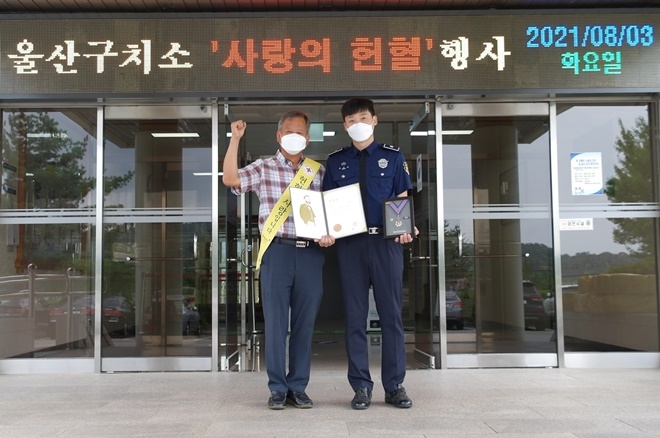 울산혈액원 이장호(좌) 과장과 헌혈유공포장 은장과 포장증을 수여받은 울산구치소 황정목(우) 교위.(사진제공=울산구치소)