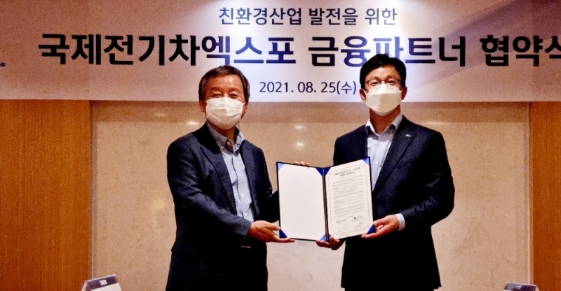 김대환 (사)국제전기자동차엑스포 이사장(왼쪽)과 정지호 신한은행 대기업외환그룹장이 25일 대한상공회의소에서 업무협약을 체결한 후 기념촬영을 하고 있다.