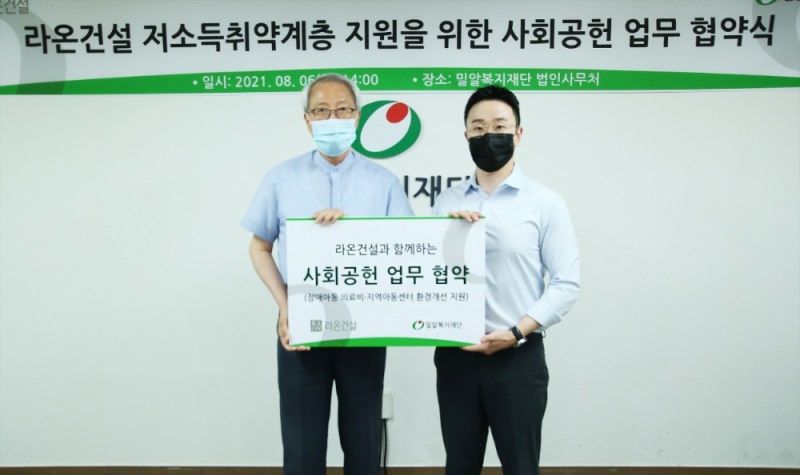 손형석 라온건설 기획본부장(오른쪽)과 정형석 밀알복지재단 상임대표가 지난 8월 저소득취약계층 지원을 위한 사회공헌 업무 협약 체결 후 기념사진을 촬영하고 있다.(사진=라온건설)