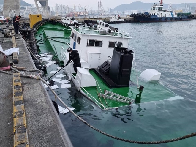 해양오염 방지를 위해 선박 에어벤트 봉쇄하고 인근 해상에 오일펜스 설치 및 잔존유 회수 작업을 진행하고 있다.(사진제공=부산해양경찰서)