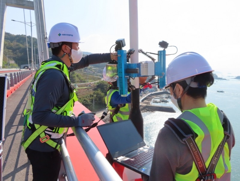 국토안전관리원 직원들이 케이블 점검 로본의 작동 상태를 살피는 모습.(사진=국토안전관리원)