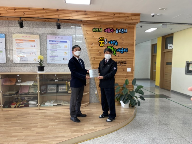 한국교통안전공단 조경수 기획본부장(왼쪽)과 김천 농소초등학교 어성천 교장(오른쪽)이 교실숲 현판 전달식 후 기념사진 촬영을 하고 있다.(사진=한국교통안전공단)