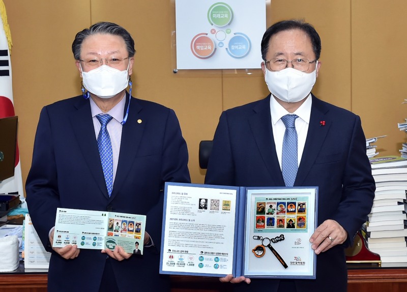 김석준 부산광역시교육감(우측)이 22일 오후 4시 교육감실에서 김동헌 대한결핵협회부산시지부 회장으로부터 크리스마스 씰을 전달받은 후, 성금을 기부하고 있다.(사진제공=부산교육청)