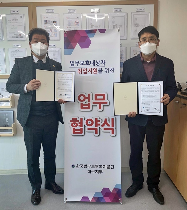서영우 대표(왼쪽)와 김주병 지부장이 업무협약서를 내보이며 기념촬영.(사진제공=한국법무보호복지공단대구지부)