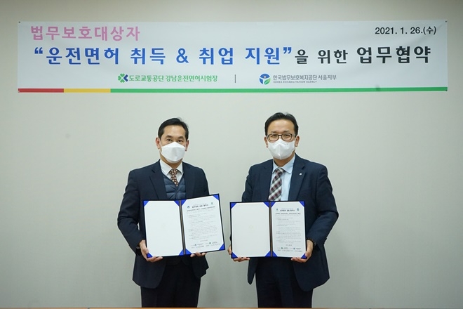 한국법무보호복지공단 서울지부 양희철 지부장, 도로교통공단 강남운전면허시험장 이상철 시험단장이 업무협약서를 내보이고 있다.(사진제공=한국법무보호복지공단 서울지부)