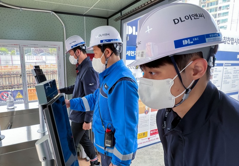 DL이앤씨 건설 현장에서 직원이 안면 인식 기기를 통해 출결을 등록하고 있다.(사진=DL이앤씨)