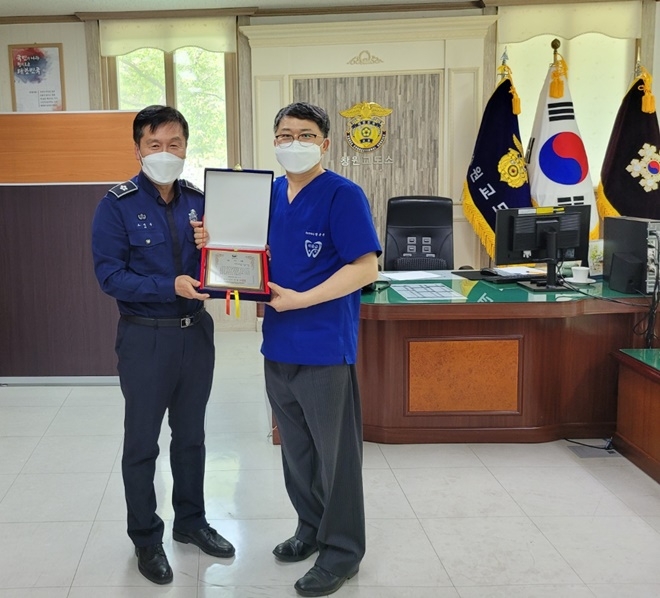 오세홍 창원교도소장이 박윤규 교정위원에게 법무부장관 감사패를 전달하고 기념촬영.(사진제공=창원교도소)