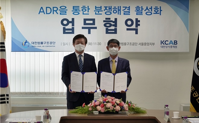 김진수 대한법률구조공단 이사장(오른쪽)과 맹수석 대한상사중재원 원장이 업무협약을 체결한 뒤 기념촬영을 하고 있다.(사진제공=대한법률구조공단)