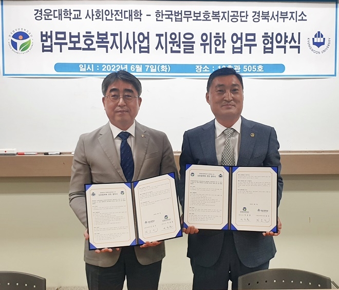 경운대학교 사회안전대학 김효진 학과장(사진왼쪽)과 공단 경북서부지소 박광흠 소장이 업무협약서를 내보이며 기념촬영.(사진제공=한국법무보호복지공단경북서부지소)