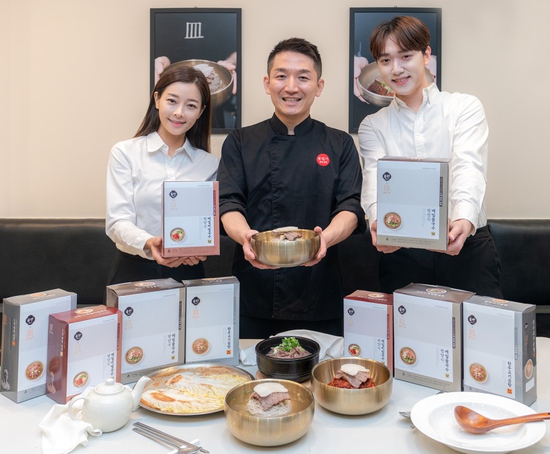 <사진설명 : 8일 서울 강남구 삼성동 봉밀가 강남구청점에서 권희승 봉밀가 대표(가운데)와 모델들이 신세계푸드가 미쉐린 가이드 서울에 5년 연속 선정된 냉면맛집 봉밀가와 협업을 통해 출시한 평양식 메밀국수와 한우고기곰탕 등 간편식을 소개하고 있다. 평양식 메밀국수는 메밀물국수와 메밀비빔국수 2종으로 판매되며 메밀가루, 밀가루, 정제염을 최적의 비율로 배합해 부드러운 식감의 면을 맛 볼 수 있는 것이 특징이다. 한우고기곰탕은 100% 한우로 우려낸 진한 육수과 얇게 썰어낸 한우사태살을 즐길 수 있다. 오는 11일 오후 7시 카카오쇼핑라이브를 통해 론칭하며 카카오톡 선물하기에서도 구입할 수 있다. / 사진 : 신세계푸드> 