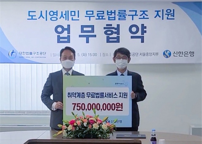 김진수 대한법률구조공단 이사장(오른쪽)과 진옥동 신한은행장이 업무협약을 체결한 뒤 기념촬영을 하고 있다.(사진제공=대한법률구조공단)