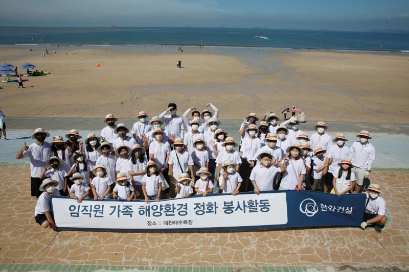한화건설 임직원 가족들이 대천해수욕장 해양환경 정화 봉사활동에 참여하고 기념사진을 촬영하고 있다.(사진=한화건설)