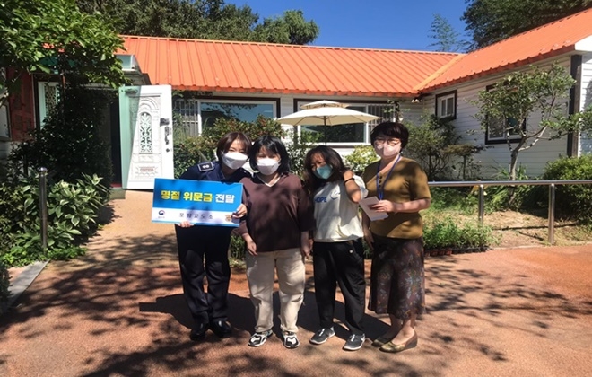 포항교도소 교감 송윤주가 명절 위문금을 전달하고 기념촬영을 하고 있다.(사진제공=포항교도소)