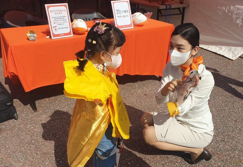 22일 서울 여의도공원에서 진행된 ‘항공안전체험교실’에서 제주항공 객실승무원들이 어린이들에게 비상상황 발생시 산소마스크 착용 방법을 가르쳐 주고 있다.(사진=제주항공)