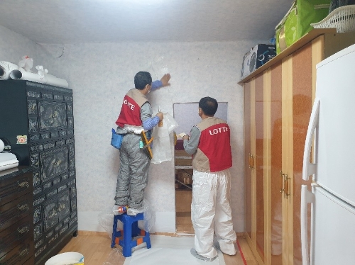 사진=롯데건설 샤롯데 봉사단이 벽지 도배 공사를 진행하고 있다.