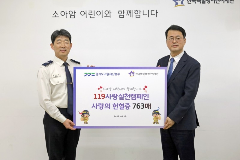 권용성 소방행정과장이 서선원 한국백혈병어린이재단 사무총장에게 헌혈증서를 전달한뒤 기념촬영을 하고 있다.