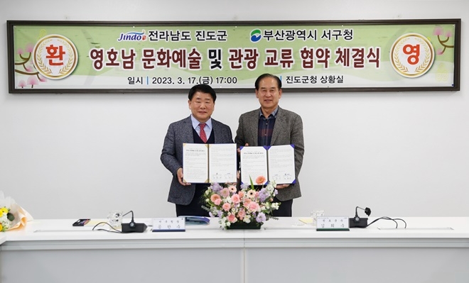 공한수 부산서구청장(사진왼쪽)과 김희수 전남 진도군수(사진 오른쪽)가 영호남 문화예술 및 관광 교류 협약서를 내보이며 기념촬영.(사진제공=부산 서구)