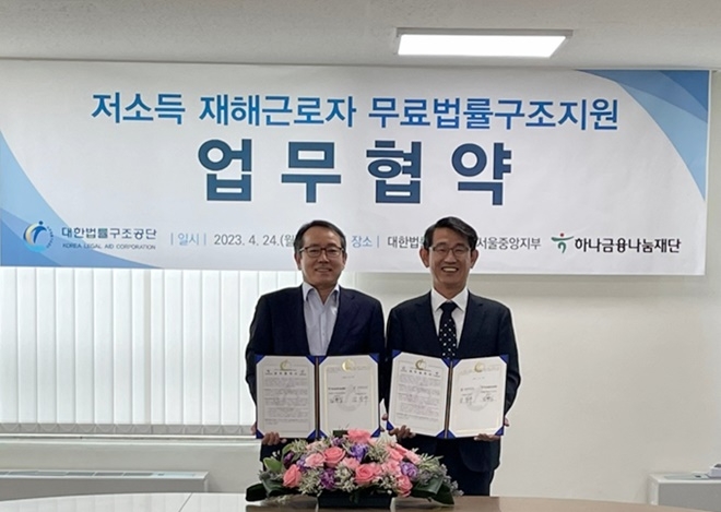 김진수 대한법률구조공단 이사장(오른쪽)과 김화식 하나금융나눔재단 상근이사가 24일 업무협약서를 내보이며 기념촬영.(사진제공=대한법률구조공단)