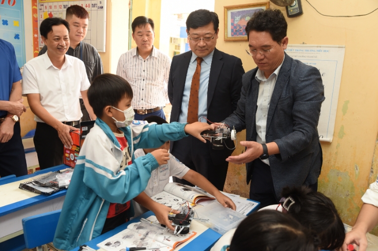 지난해 11월 진행된 LS드림스쿨 IT교실에서 LS메탈 정혁 법인장(가운데)과 코피온 김재철 지부장(오른쪽)이 로봇 코딩 클래스 교육을 참관하고 있다. 사진=LS그룹