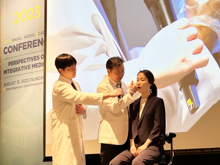 자생한방병원 설립자 신준식 박사(가운데)가 2023 자생국제학술대회 기조 강연을 통해 턱관절 장애 한의 치료법을 직접 시연하고 있다. 사진=자생한방병원