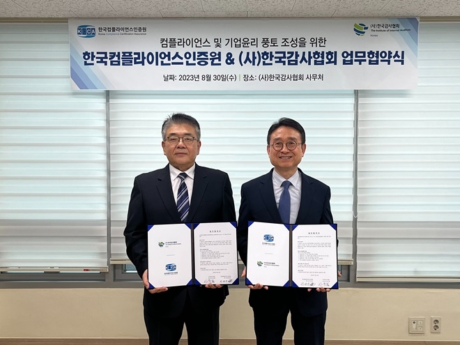 한국감사협회 이욱희 회장(사진우측)과한국컴플라이언스인증원 이원기 원장이 업무협약서를 내보이며 기념촬영. (사진제공=한국감사협회)