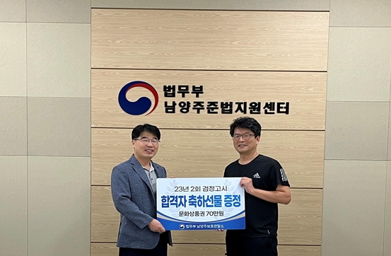 최상현 소장(사진 왼쪽)과 한상원 보호관찰계장이 축하선문증정 팻말을 들고 기념촬영.(사진제공=남양주준법지원센터)