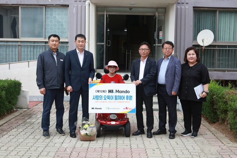 HL만도와 한국교통안전공단이 지난 21일 전라북도 익산시에 거주하는 수혜자 자택을 방문하여 ‘사랑의 오뚝이 휠체어’ 기증식을 가졌다. HL만도 서스펜션 BU 김근도 경영지원실장(왼쪽 끝에서 두번째), 한국교통안전공단 장찬옥 교통안전본부장(오른쪽 끝에서 세번째).(사진=HL만도)