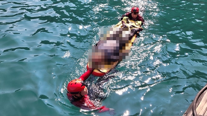 27일 구조보드를 이용해 응급환자를 이송하고 있다.(사진제공=부산해양경찰서)