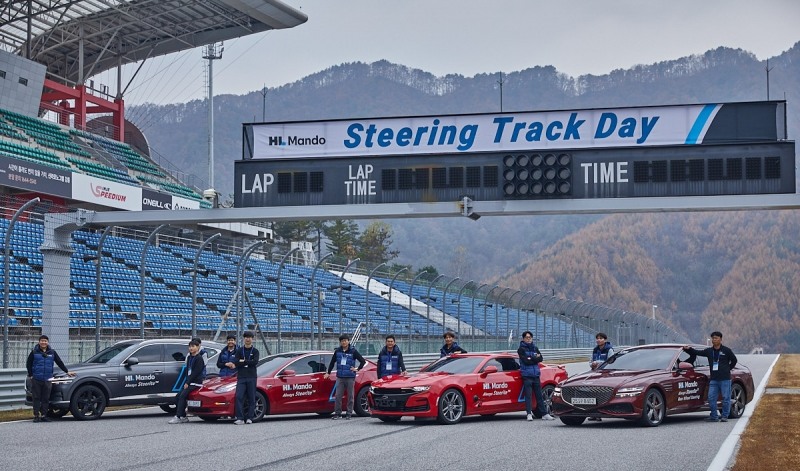 HL만도 스티어링 BU 인원들이 'SbW 서킷 택시'와 함께 기념 촬영을 하고 있다.(사진=HL만도)