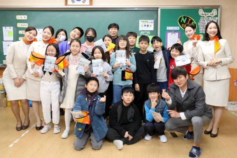 제주항공 객실승무원들이 어린이들에게 친환경 여행 용품을 선물하고 기념촬영을 하고 있다.(사진=제주항공)