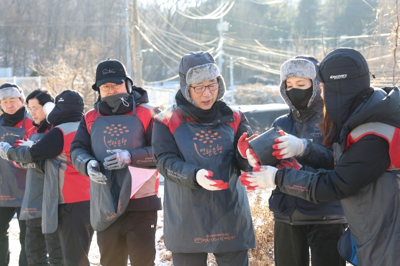 롯데건설 박현철 부회장(오른쪽 세번째)과 배우 정애리(오른쪽 두번째)가 임직원들과 함께 연탄을 나르고 있다.(사진=롯데건설)