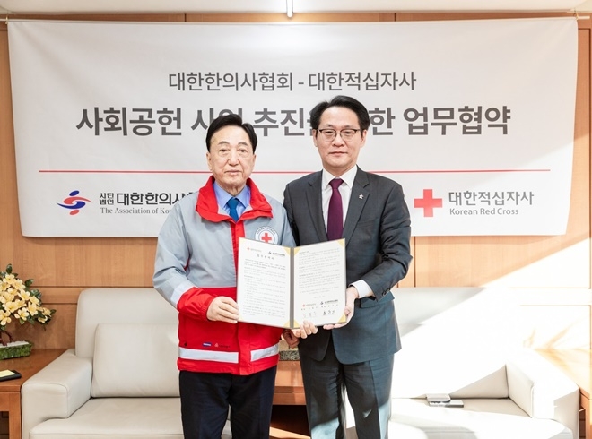 김철수 대한적십자사 회장(사진 왼쪽)과 홍주의 대한한의사협회 회장(사진 오른쪽)이 협약서를 내보이며 기념촬영.(사진제공=대한적십자사)