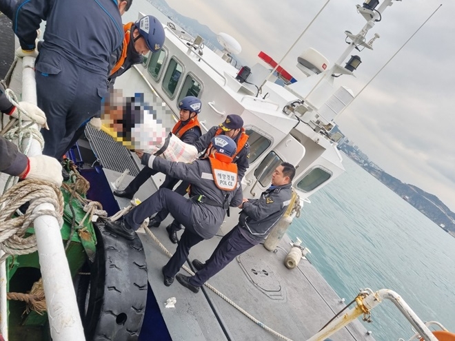 응급처치 및 들것으로 고정 후 환자를 남항파출소 연안구조정으로 옮기는 모습.(사진제공=부산해양경찰서)