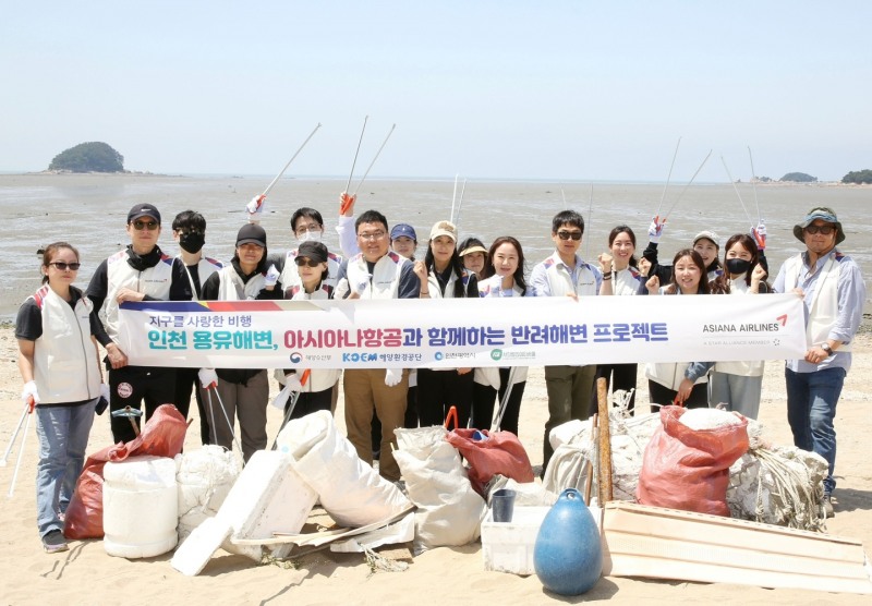 아시아나항공 직원들이 23일 인천 용유해변에서 정화 활동을 마친 후 기념 사진을 찍고 있다.(사진=아시아나항공)