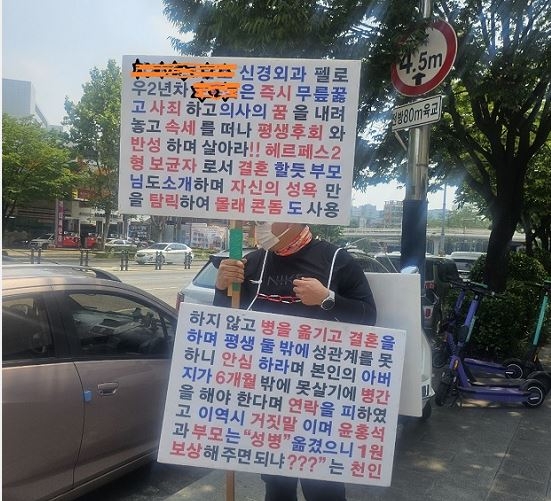 피해자측 인척이 전공의 의사가 있다는 대학병원 앞에서 ‘1인시위’를 하고 있다.