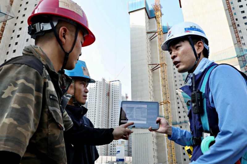 GS건설 아파트 현장에서 ‘자이 보이스’를 활용해 외국인 근로자에게 작업 유의사항을 설명하고 있는 모습.(사진=GS건설)