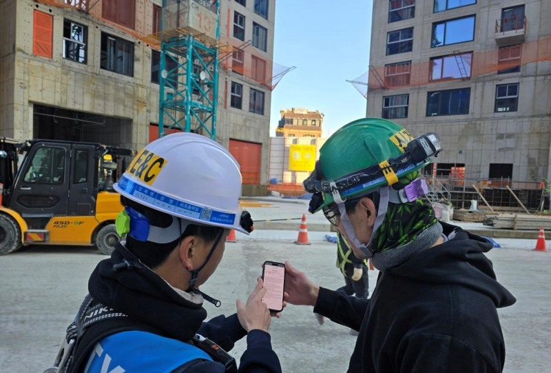 DL이앤씨 직원이 수도권의 한 아파트 건설 현장에서 외국인 노동자에게 ‘AI 자동번역 시스템’을 안내하고 있다.(사진=DL이앤씨)