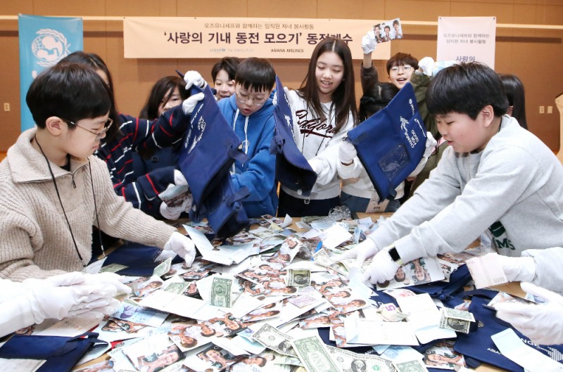 서울 강서구 아시아나항공 교육훈련동에서 임직원 자녀들이 ‘사랑의 기내 동전 모으기 캠페인’으로 모인 동전을 분류하고 있다.(사진=아시아나항공)