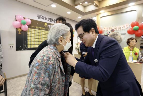 박일하 구청장이 지난해 5월 어버이날 기념으로 한 어르신에게 카네이션 꽃을 달아 드리고 있다.