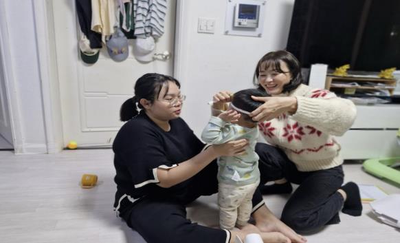 영유아 건강 간호사가 서비스를 신청한 다문화가정에 방문하여 아기의 신체 계측 및 건강 상태 평가를 하고 있다.