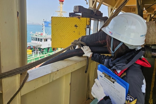 해양경찰관이 급유 이송 호스 고정상태를 확인하고 있다.(사진제공=부산해양경찰서)