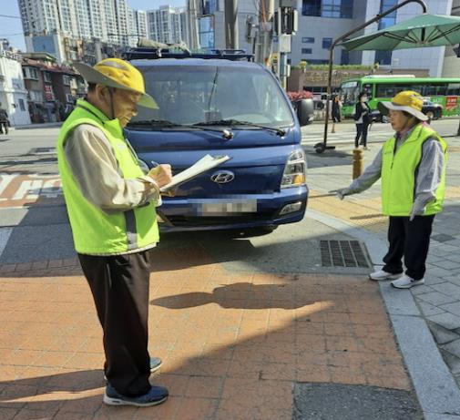 어린이의 안전을 위해 어르신들이 주차질서 안내활동을 하고 있는 모습