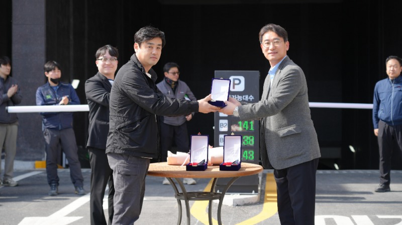 동아건설산업 김서규 건축본부장(상무, 맨 앞 오른쪽)이 지난달 말 경기 평택시 통복동(577번지 일원) ‘평택역 경남아너스빌 디아트’에서 진행된 입주 기념 점등식에 앞서 입주예정자협의회 이광현 대표로부터 감사패를 건네받으며 기념촬영을 하고 있다.(사진=SM그룹)
