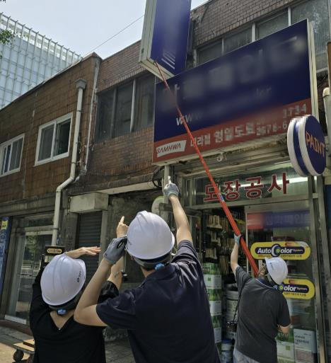 옥외광고물 접합부위의 노화, 부식 등 위험성을 확인하고 있는 모습