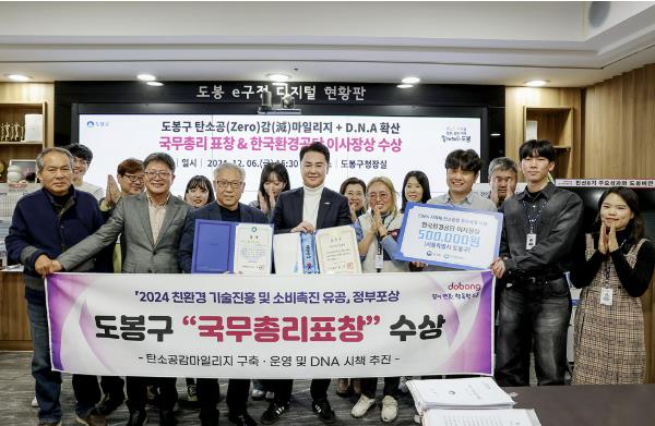 오언석 도봉구청장(가운데)과 직원들이 ‘2024 친환경 기술진흥 및 소비촉진 유공, 정부포상’에서 ‘국무총리표창’을 수상하고 이를 기념해 단체 사진을 찍고 있다